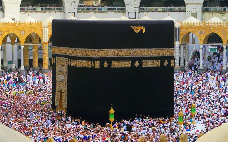 Pilgrims in ihram gathered around the Kaaba beneath the gold embroidered kiswah in Masjid al-Haram